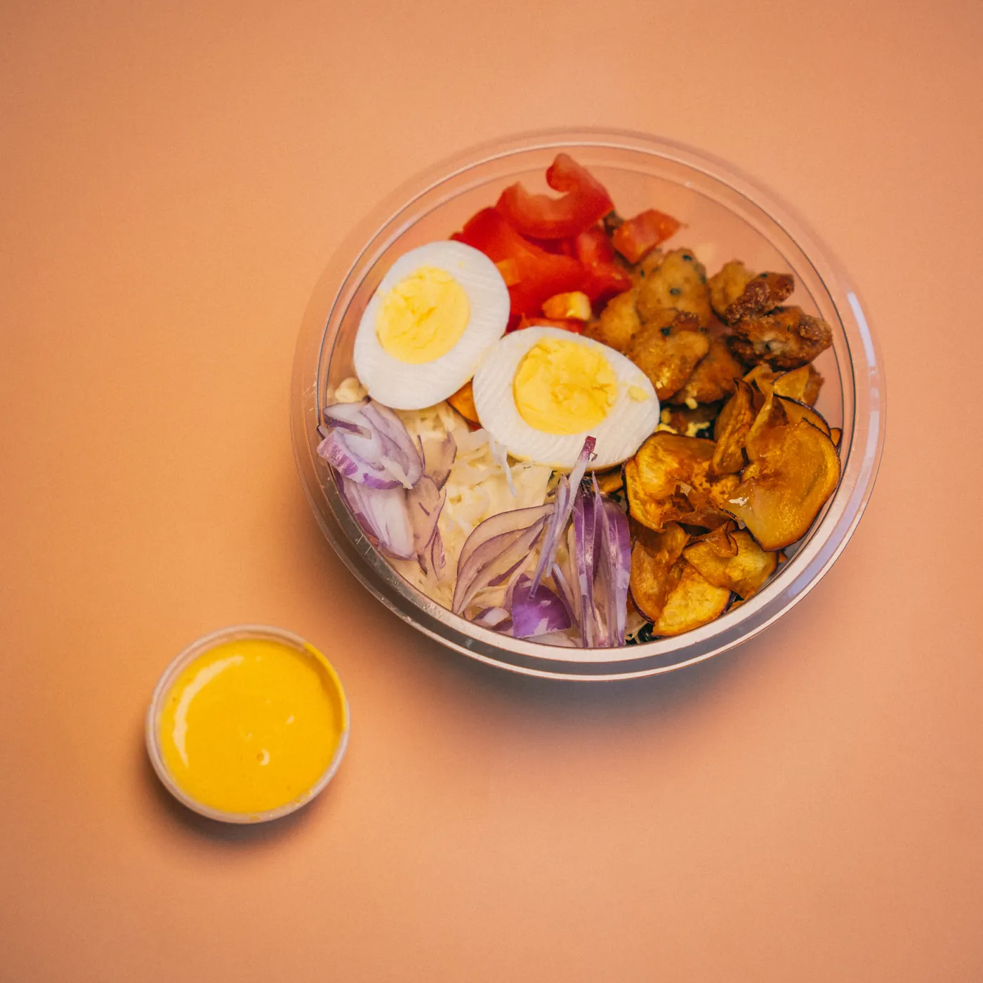 Bowl con pollo, huevo, tomate y cebolla morada