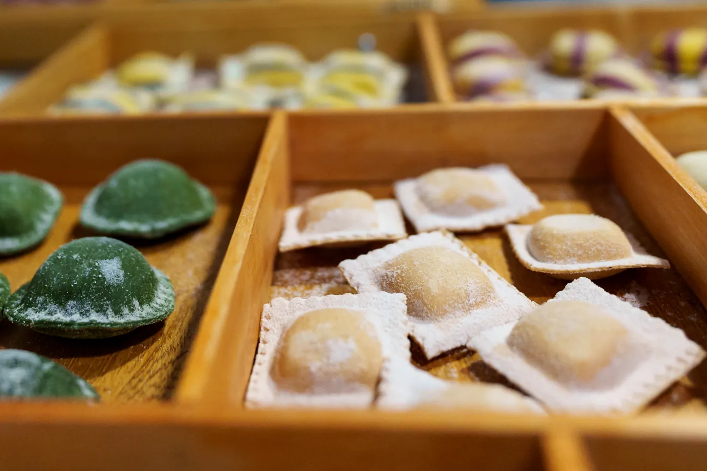 Bandejas de madera con pastas rellenas de distintos colores
