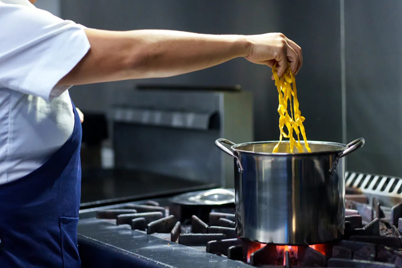 Pasta entrando a la olla con agua hirviendo