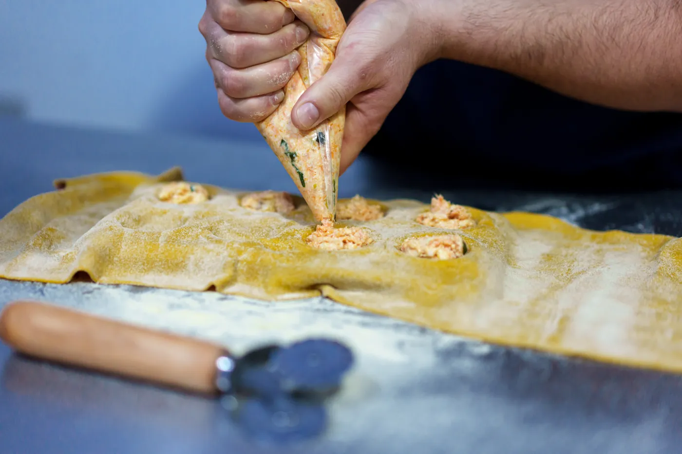 Relleno de ravioles a mano sobre la masa laminada
