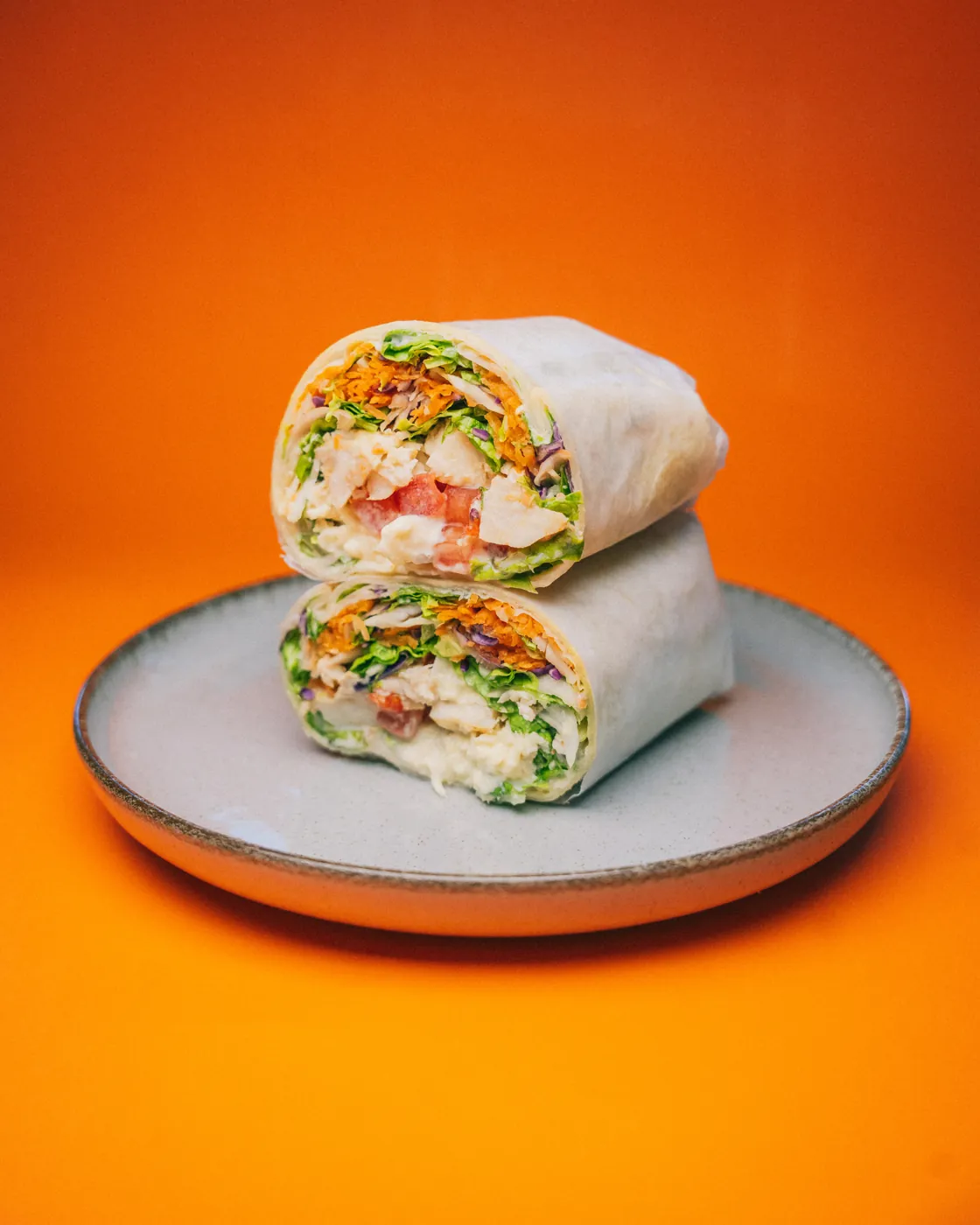 Wrap de pollo cortado al medio sobre un plato