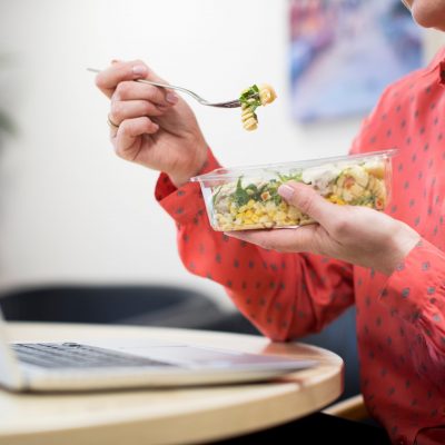 Female Worker In Office Having Healthy Pasta Lunch At Desk