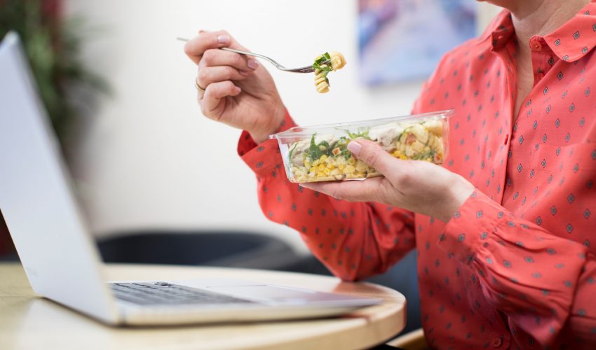 Female Worker In Office Having Healthy Pasta Lunch At Desk